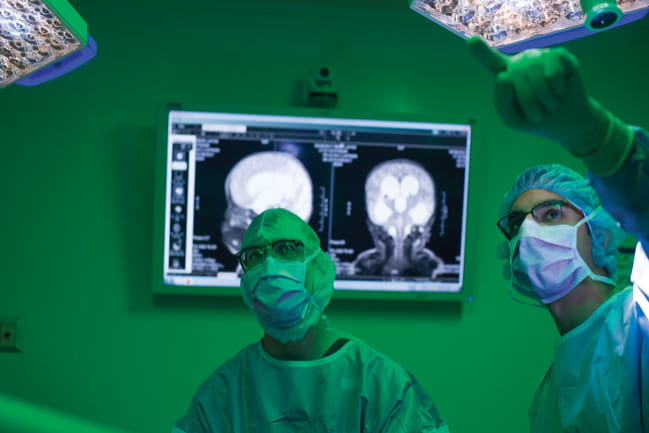 Photo of Dr. Ramin Eskandari discussing a case in operating room